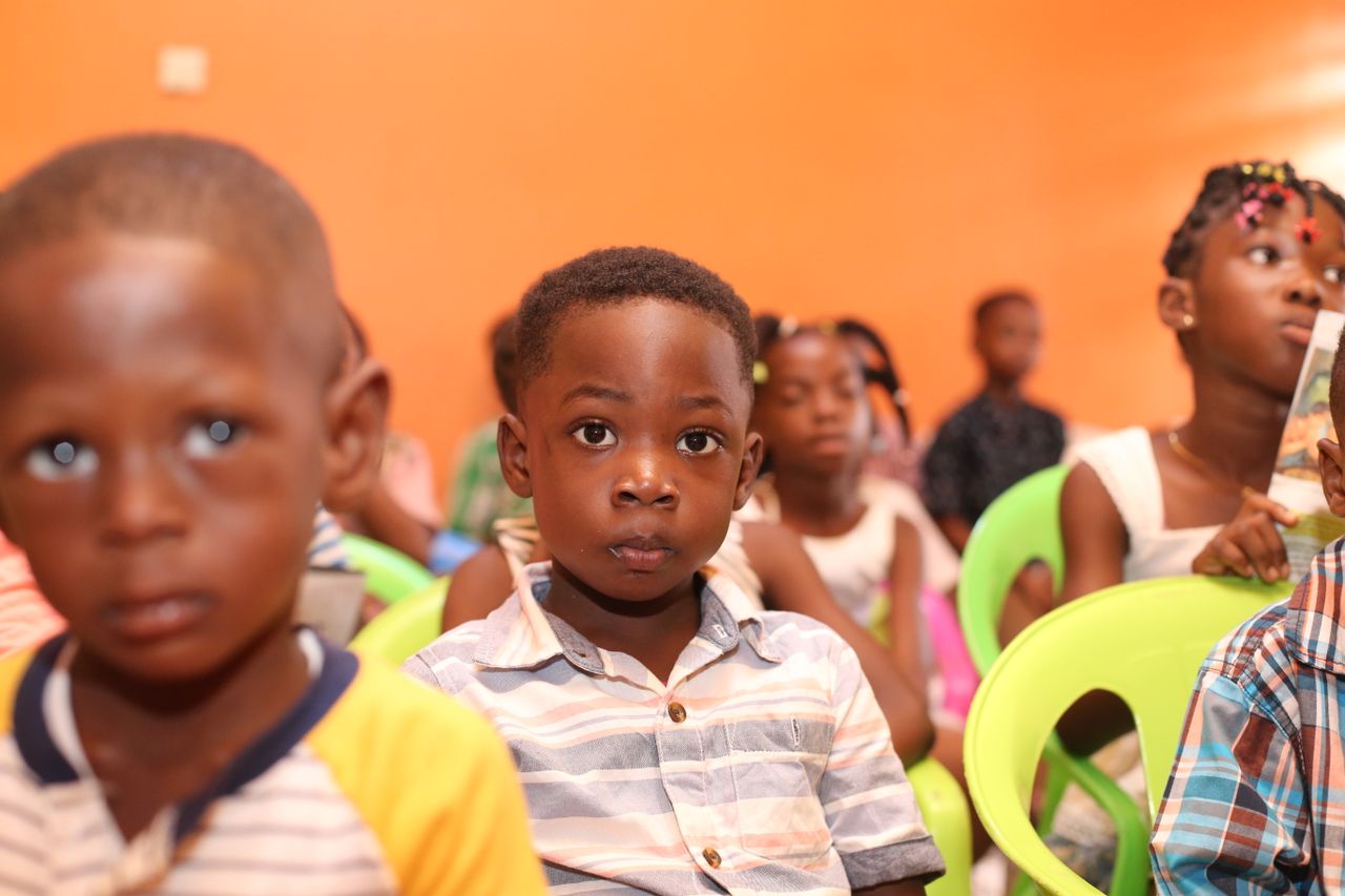 Services A group of children seated in a colorful classroom setting, focusing attentively.