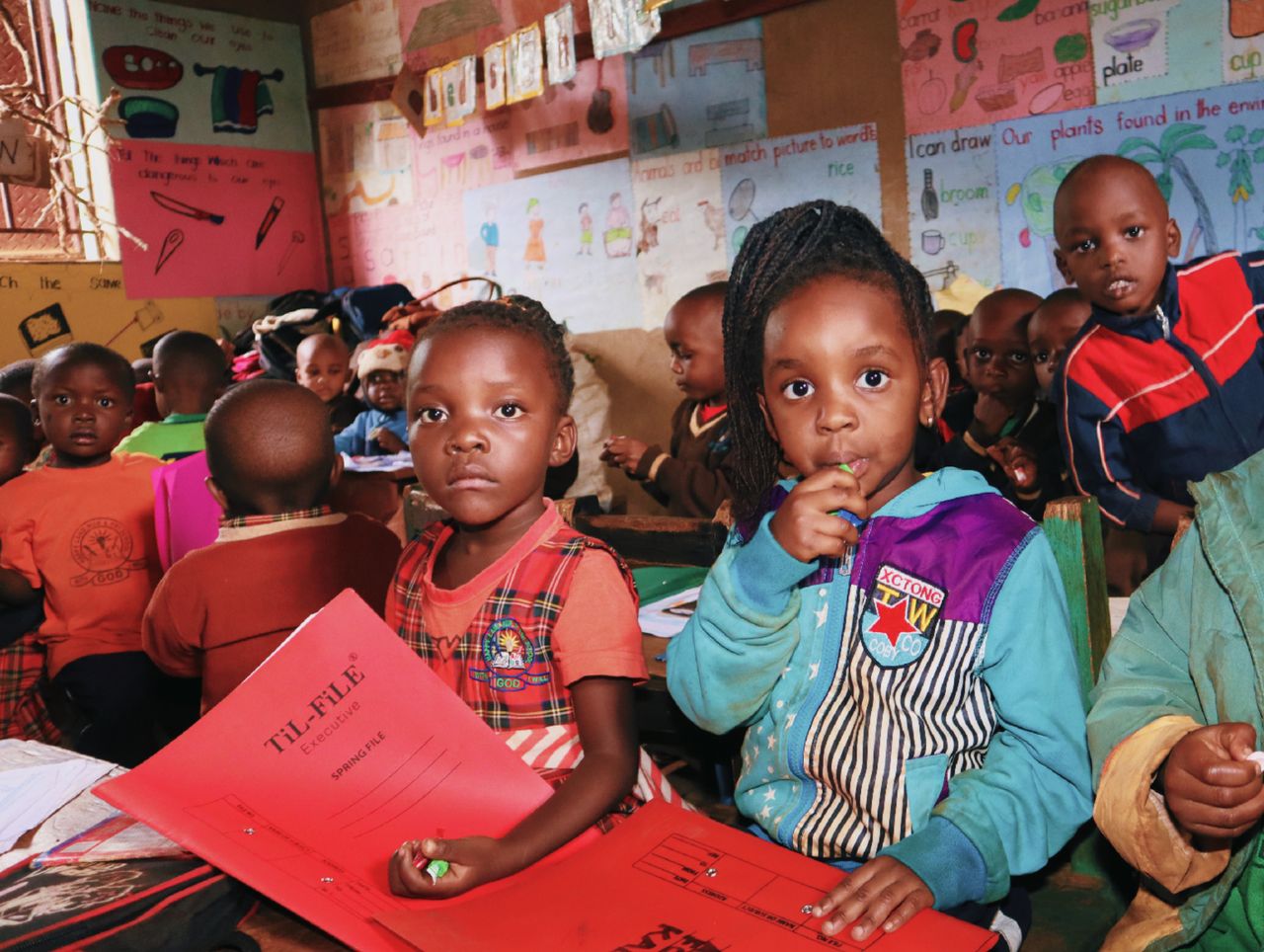 Services A group of young children engaged in an educational activity in a colorful classroom.