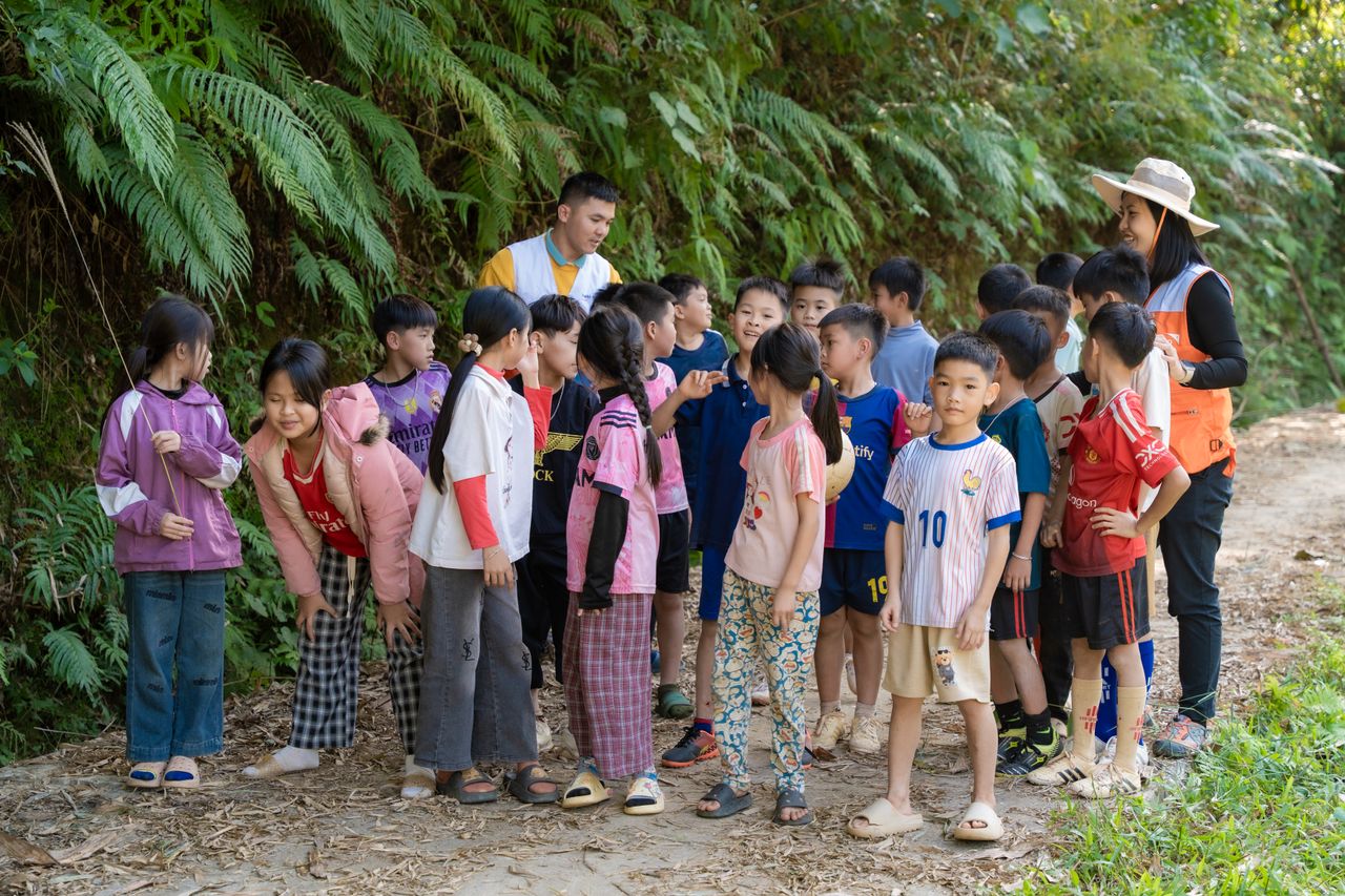 Services Group of children engaged in outdoor learning activity on a nature trail with two adult guides.